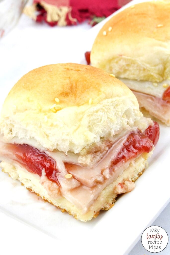 Get ready to fall in love with the ease of these Turkey Cranberry Sliders. They're so simple to make, you're going to make them again and again! Perfect to make with Thanksgiving Leftovers, THE MOST DELICIOUS turkey sliders on Hawaiian rolls with cranberry. Your family will LOVE the taste of these.