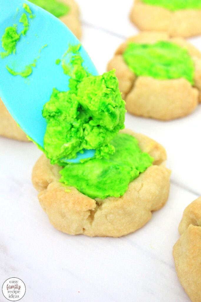These St. Patrick's Day Thumbprint Cookies dipped in white chocolate and sprinkles, are some of the best you'll ever eat! They're tasty and simple cookies to make and absolutely perfect for St. Patrick's Day! Leprechaun Thumbprint Cookies children and adults love. 
