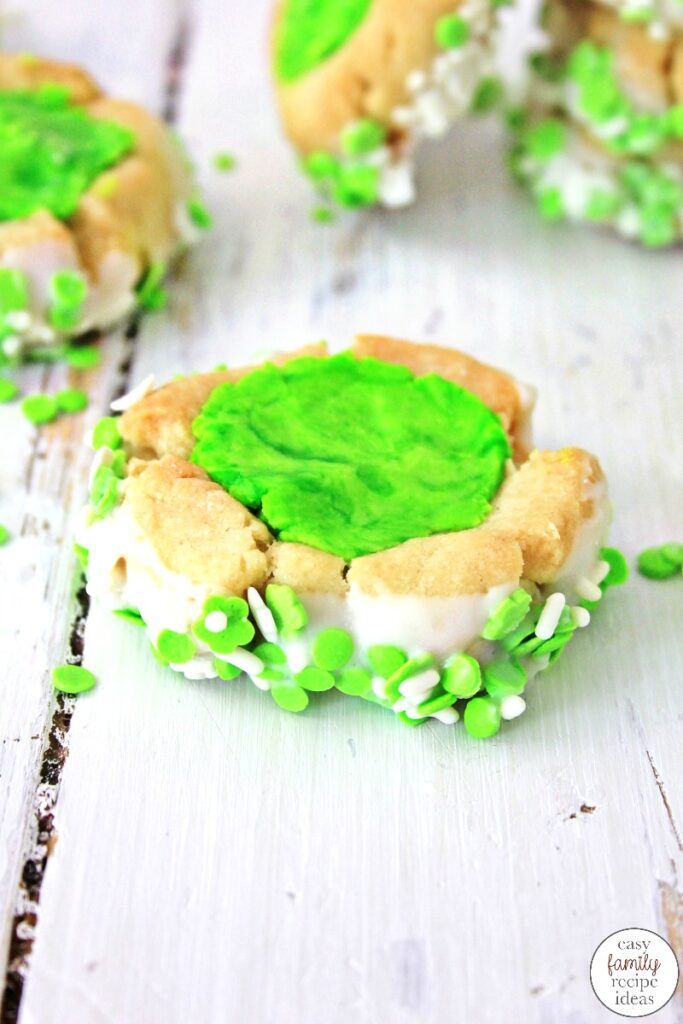 These St. Patrick's Day Thumbprint Cookies dipped in white chocolate and sprinkles, are some of the best you'll ever eat! They're tasty and simple cookies to make and absolutely perfect for St. Patrick's Day! Leprechaun Thumbprint Cookies children and adults love. 