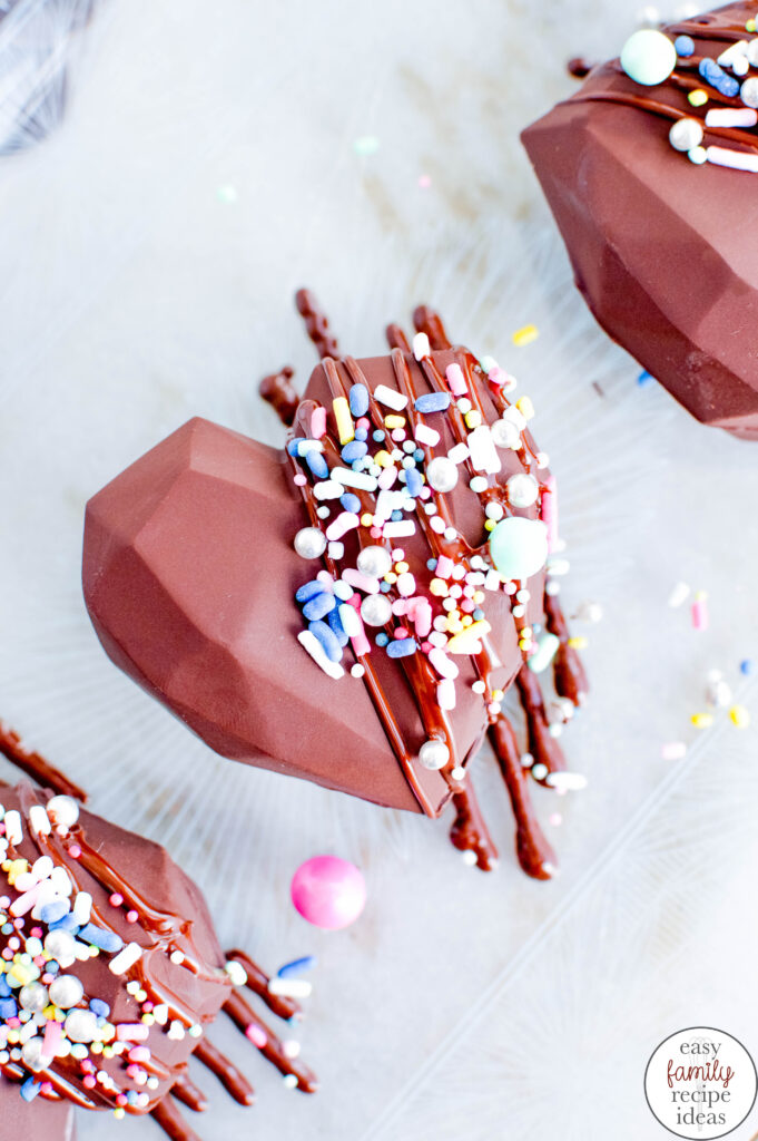 Learn how the make Valentine's Day hot chocolate bombs for enjoying and gifting this Valentine's Day! This hot chocolate bomb recipe is created with heart-shaped chocolate filled with hot cocoa powder and miniature marshmallows. These Heart hot cocoa bombs taste amazing