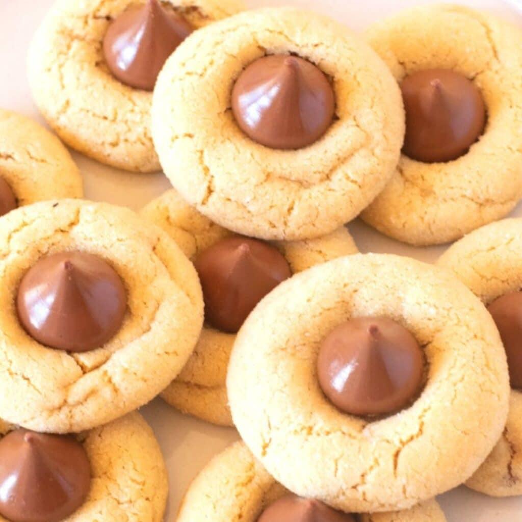 Peanut butter cookies with chocolate kisses on a plate.
