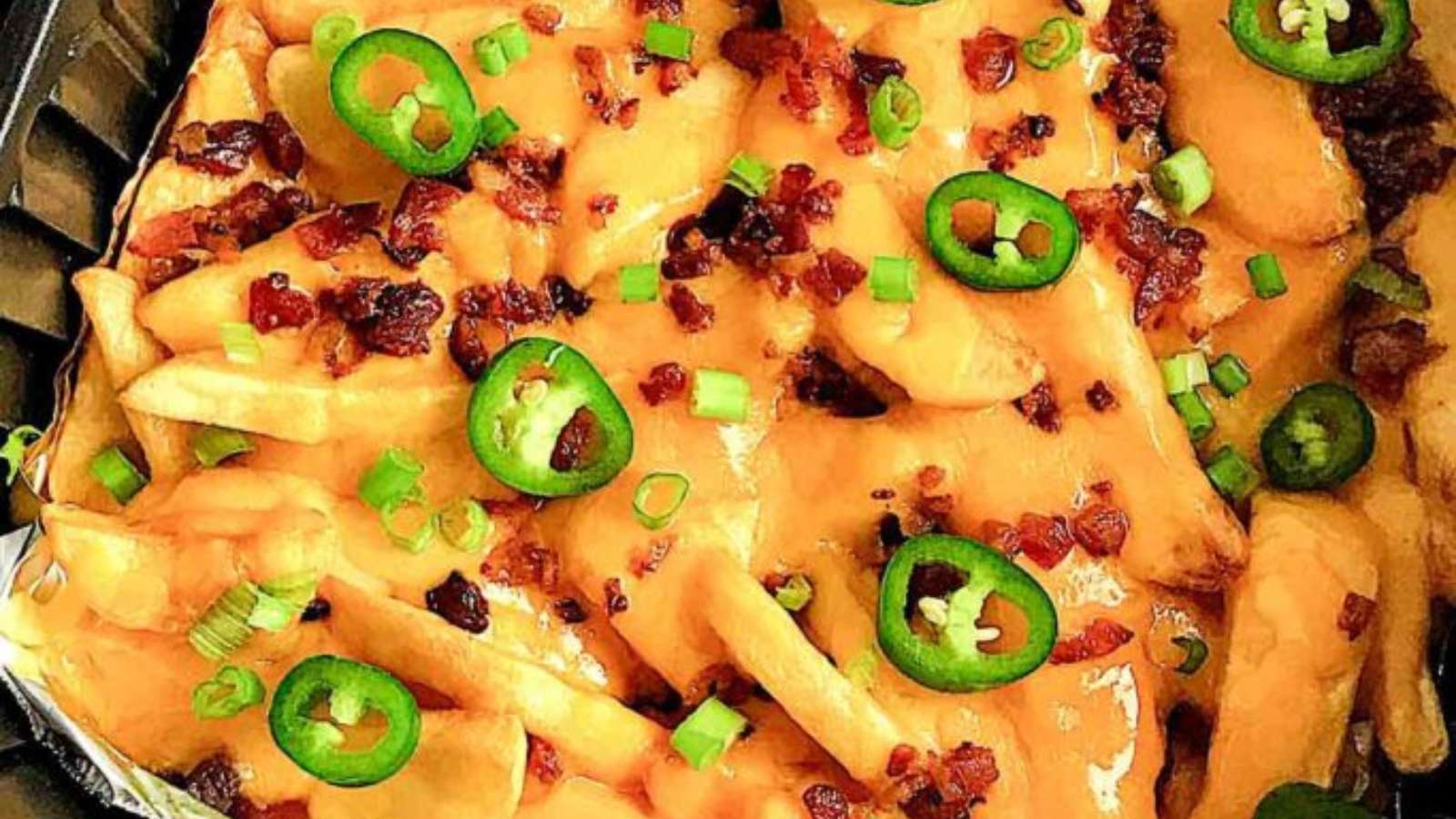 A tray of nachos with bacon and jalapenos.