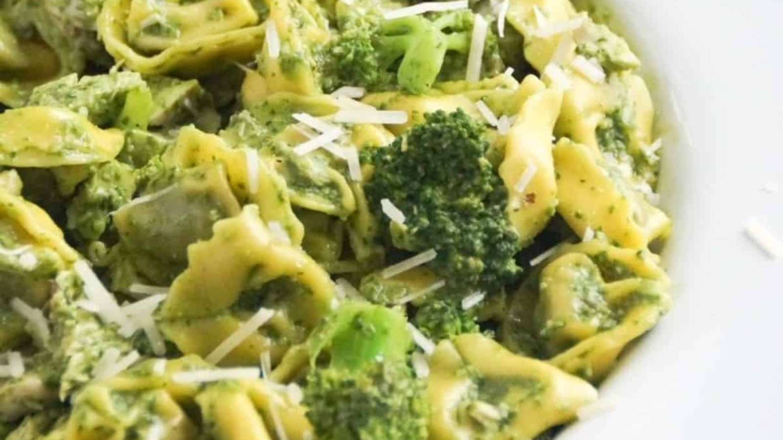 A bowl of pasta with broccoli and pesto.