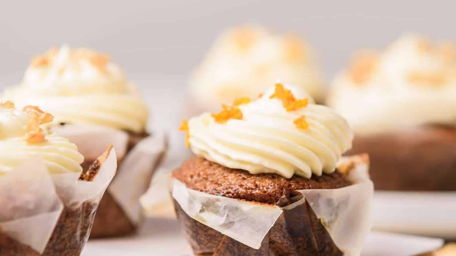 A group of cupcakes topped with frosting and orange zest.