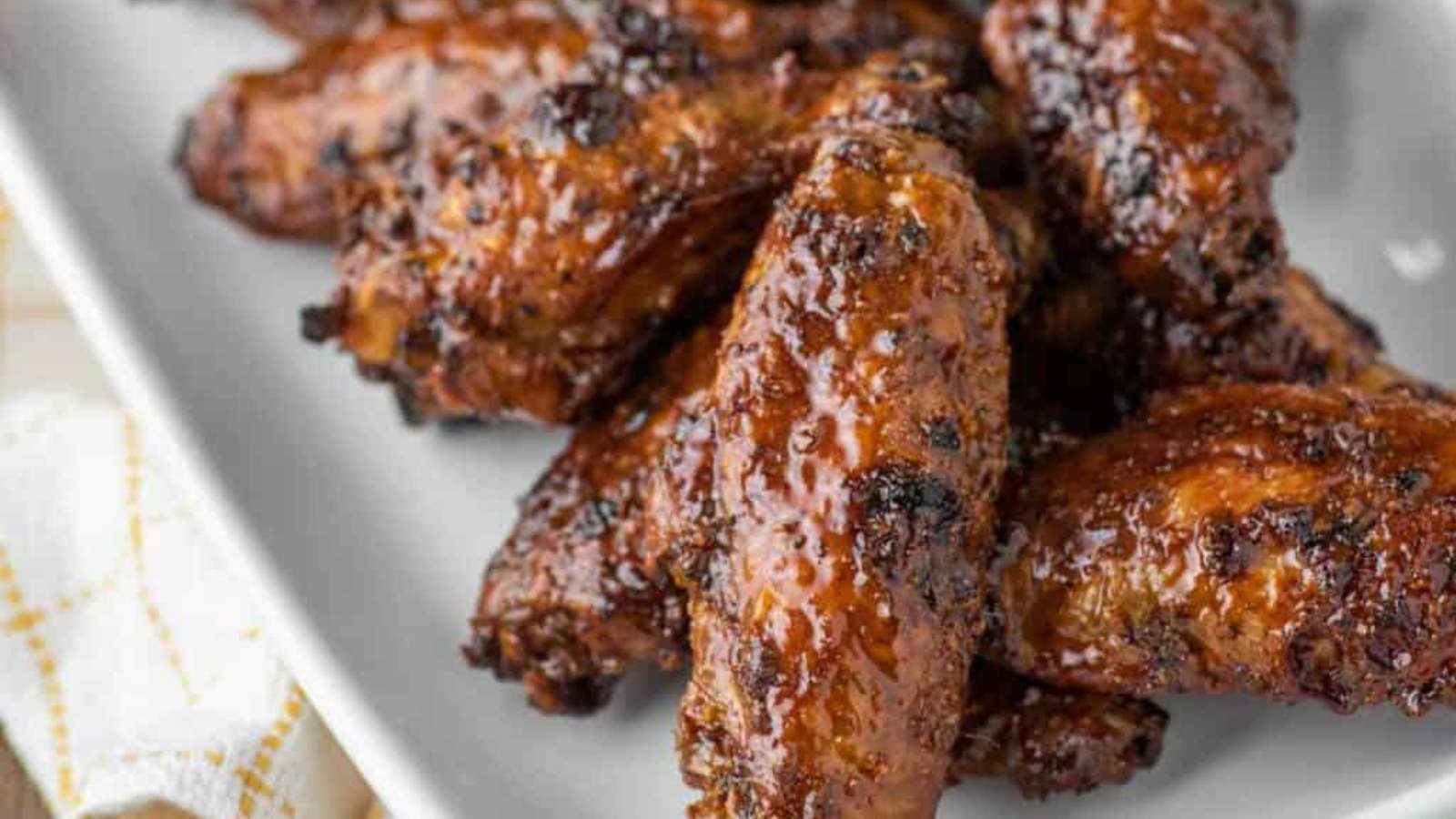 BBQ chicken wings on a white plate.