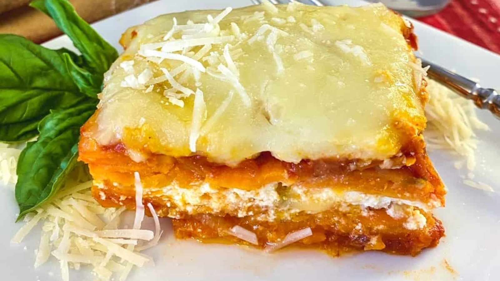 A slice of sweet potato lasagna on a white plate.