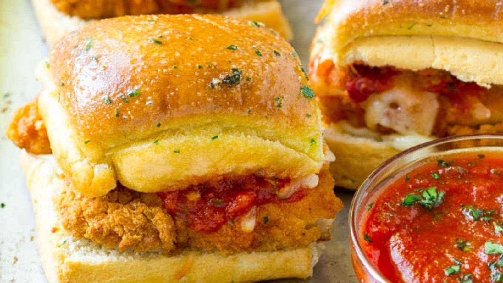 Chicken sliders with tomato sauce on a baking sheet.