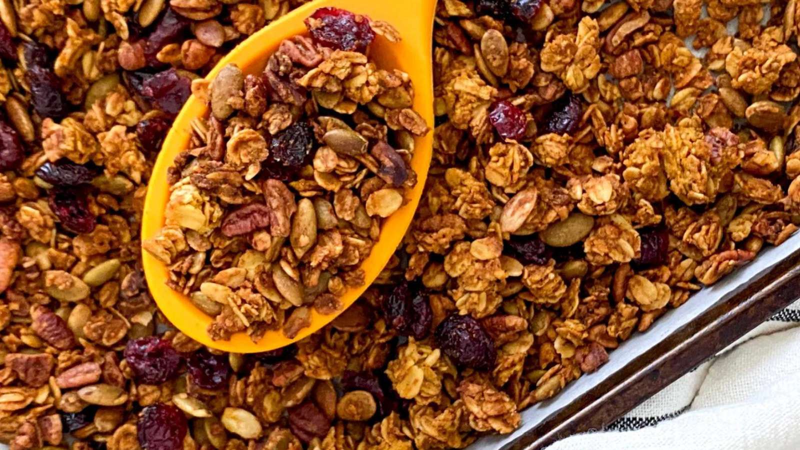 A spoonful of granola on a baking sheet.