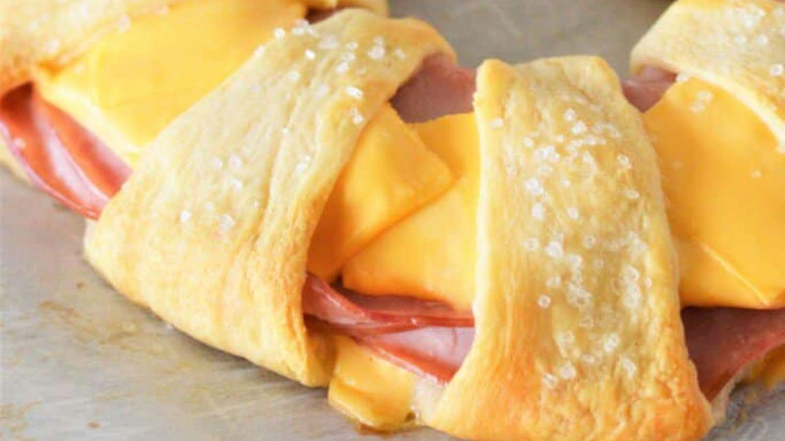A ham and cheese wreath on a baking sheet.