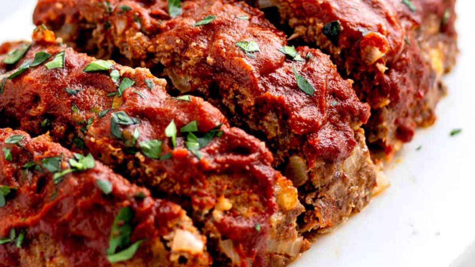 Meatloaf with sauce on a white plate.