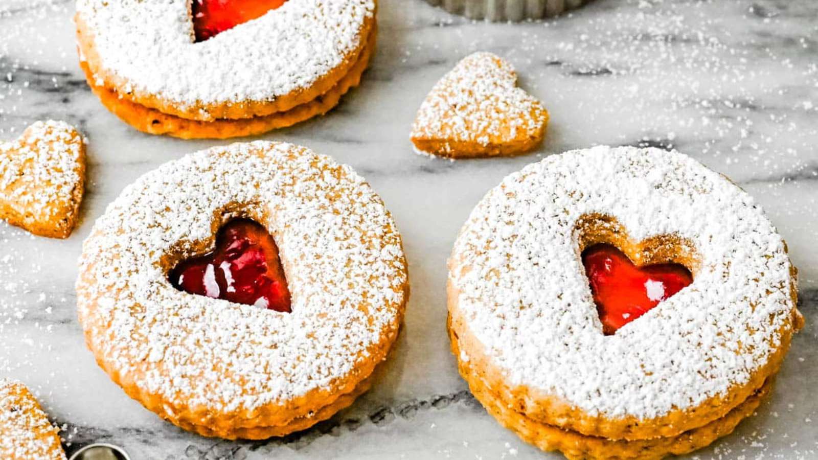 Valentine's day cookies with jam and powdered sugar.