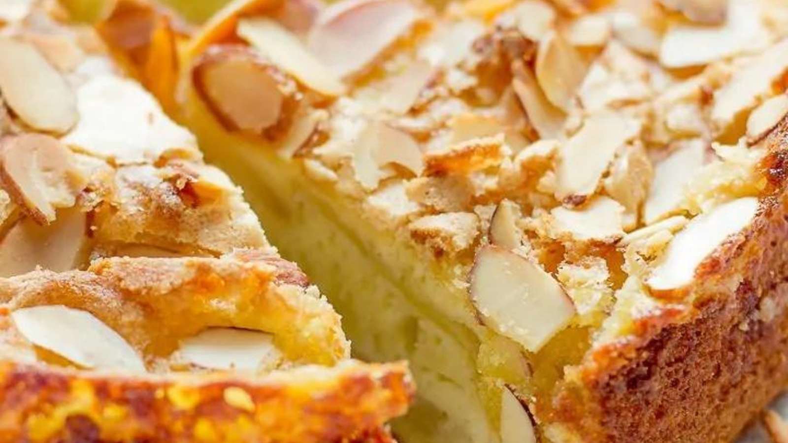 A slice of cake with almonds on top.