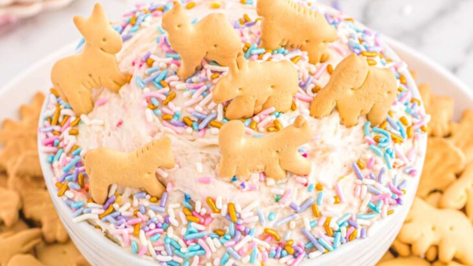 A cake dip with sprinkles and animal cookies.