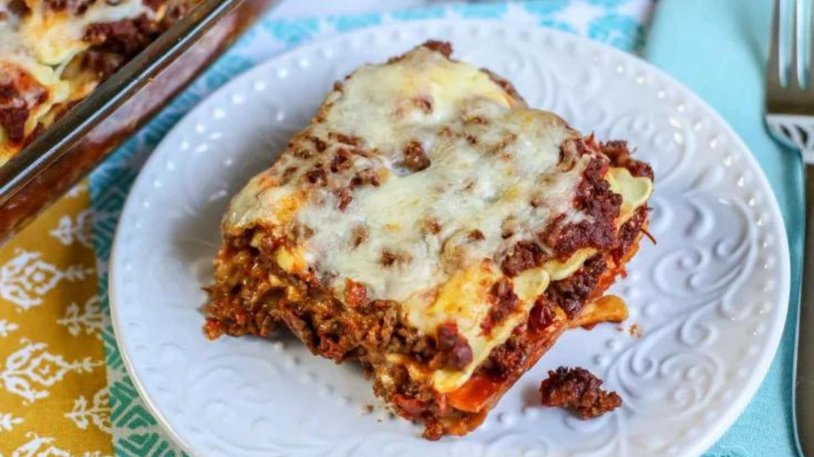 A slice of lasagna on a plate with a fork.