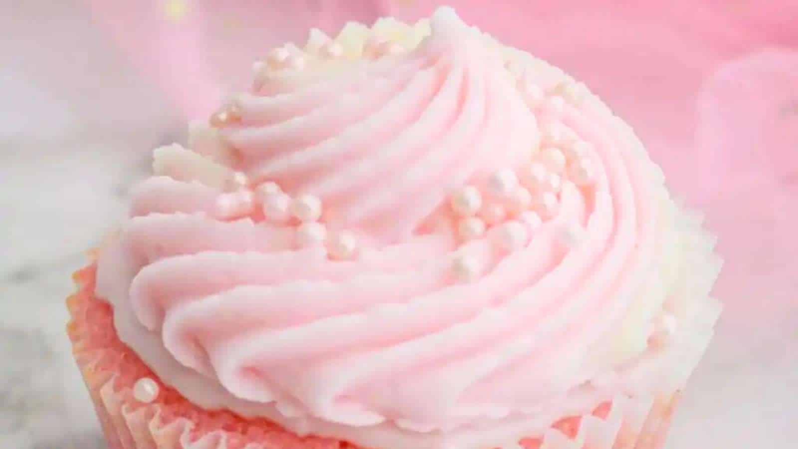 A close up of a pink frosted cupcake.