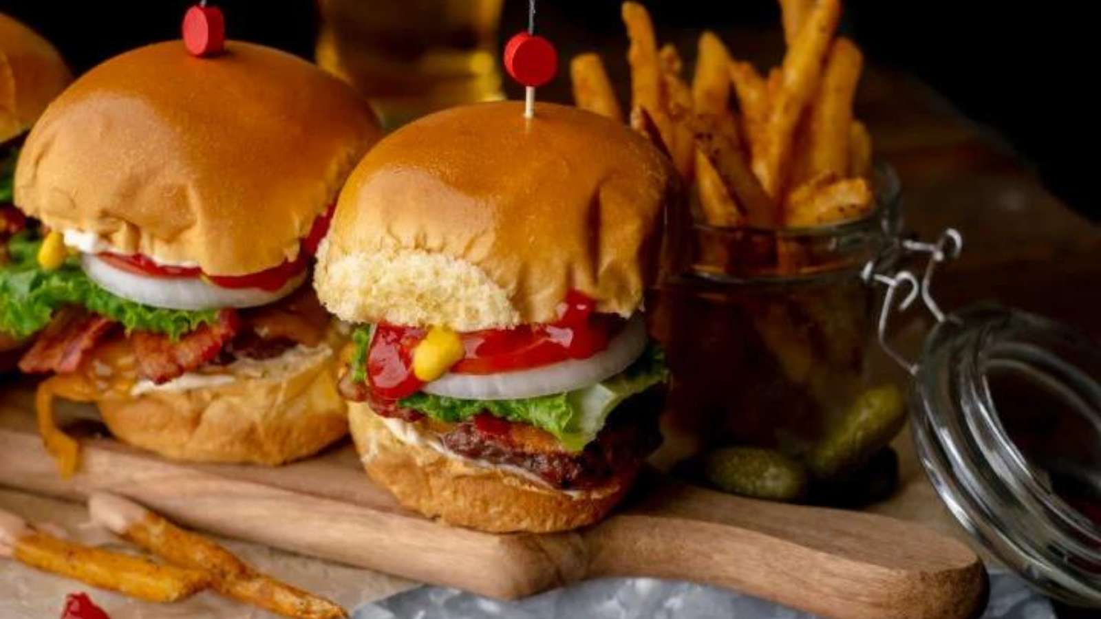 Burger sliders on a wooden cutting board.