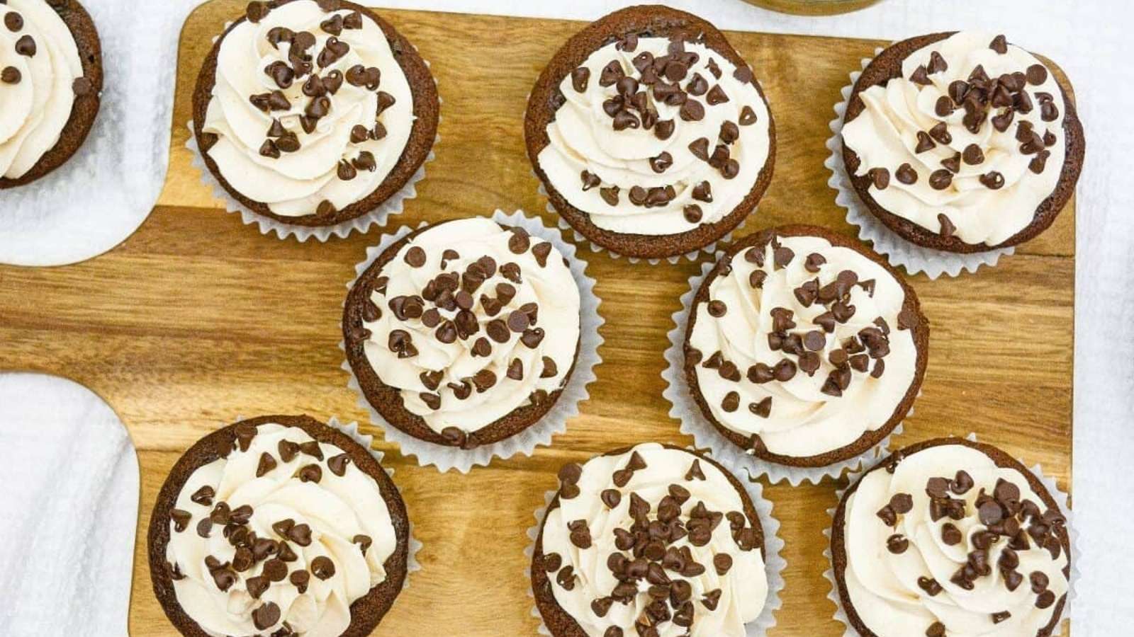 Chocolate chip cupcakes on a wooden cutting board.