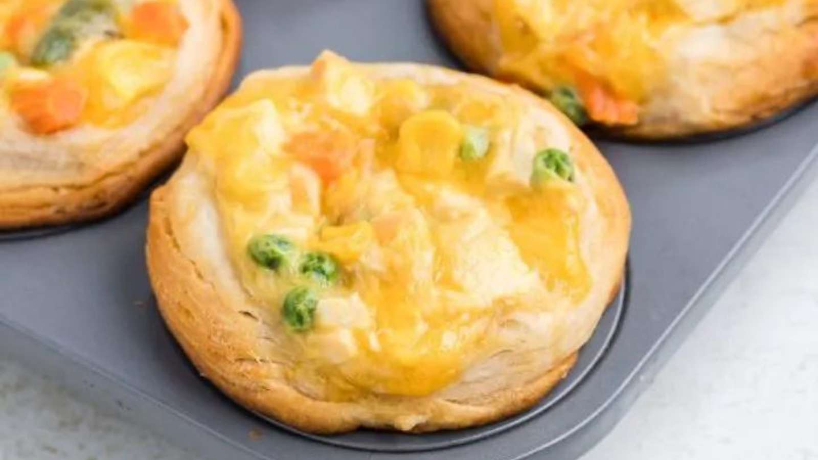 Chicken and vegetable pot pies in a muffin tin.