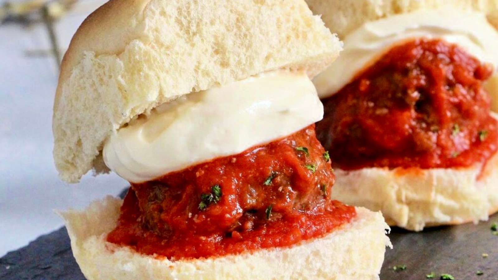 Meatball sliders with sauce and ricotta.