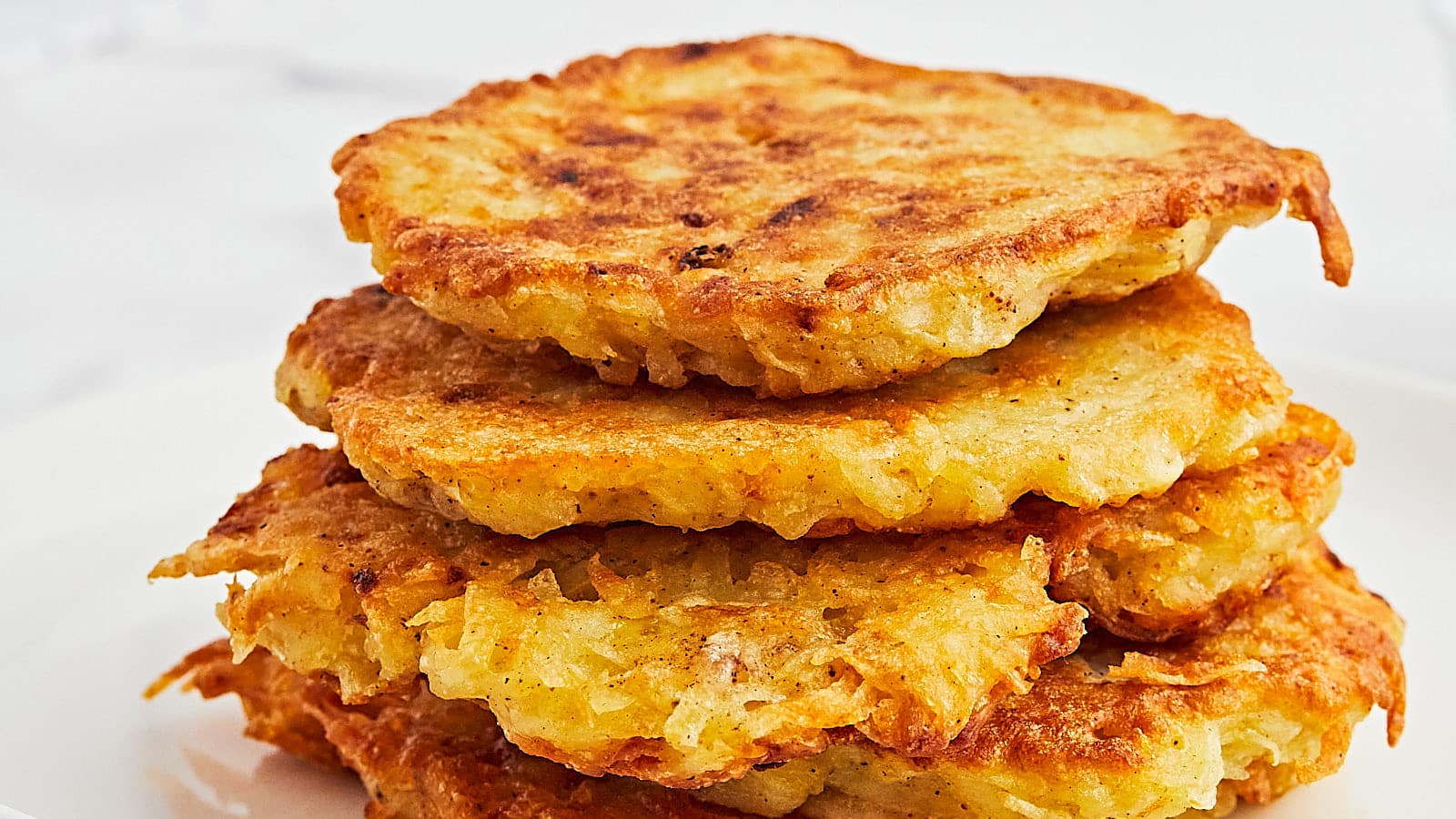 A stack of potato pancakes on a plate.