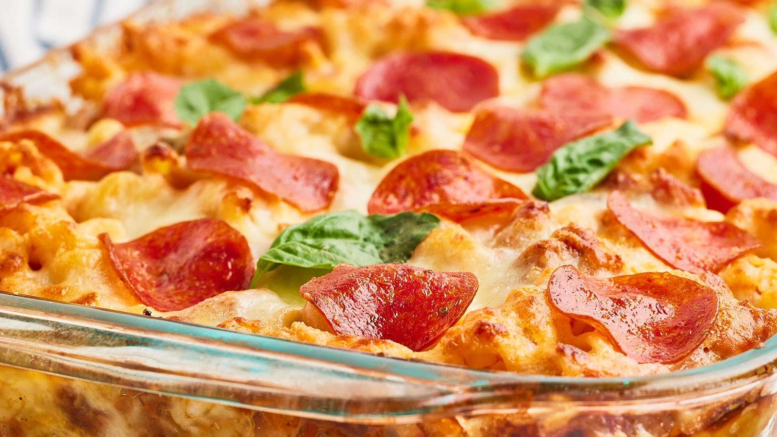 A casserole dish filled with pepperoni and cheese.