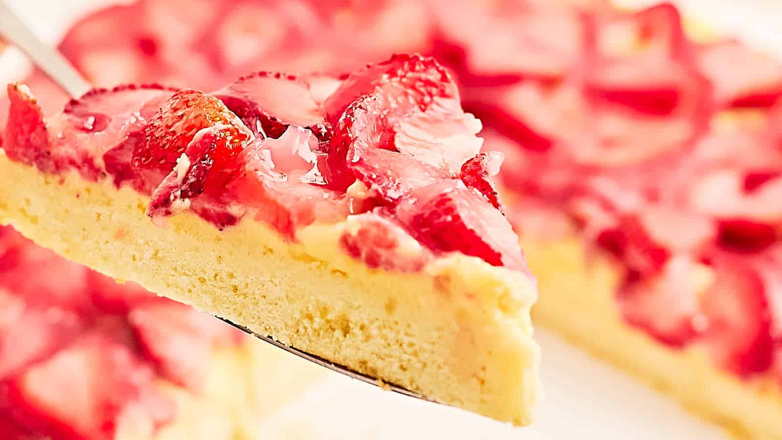 A slice of strawberry cheesecake on a fork.