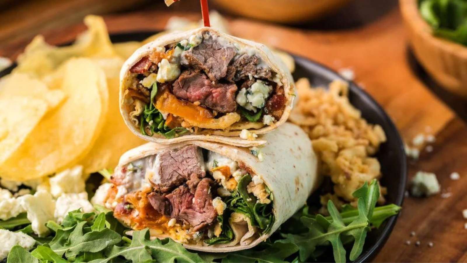 A wrap with meat and vegetables on a plate.