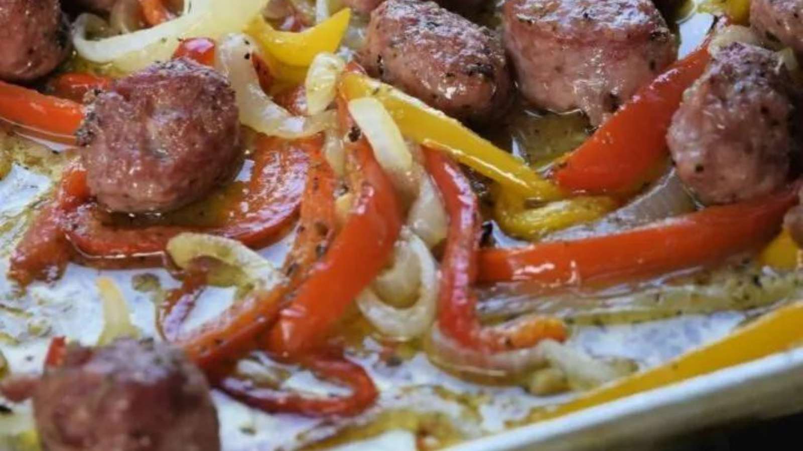 Sausage and peppers on a baking sheet.