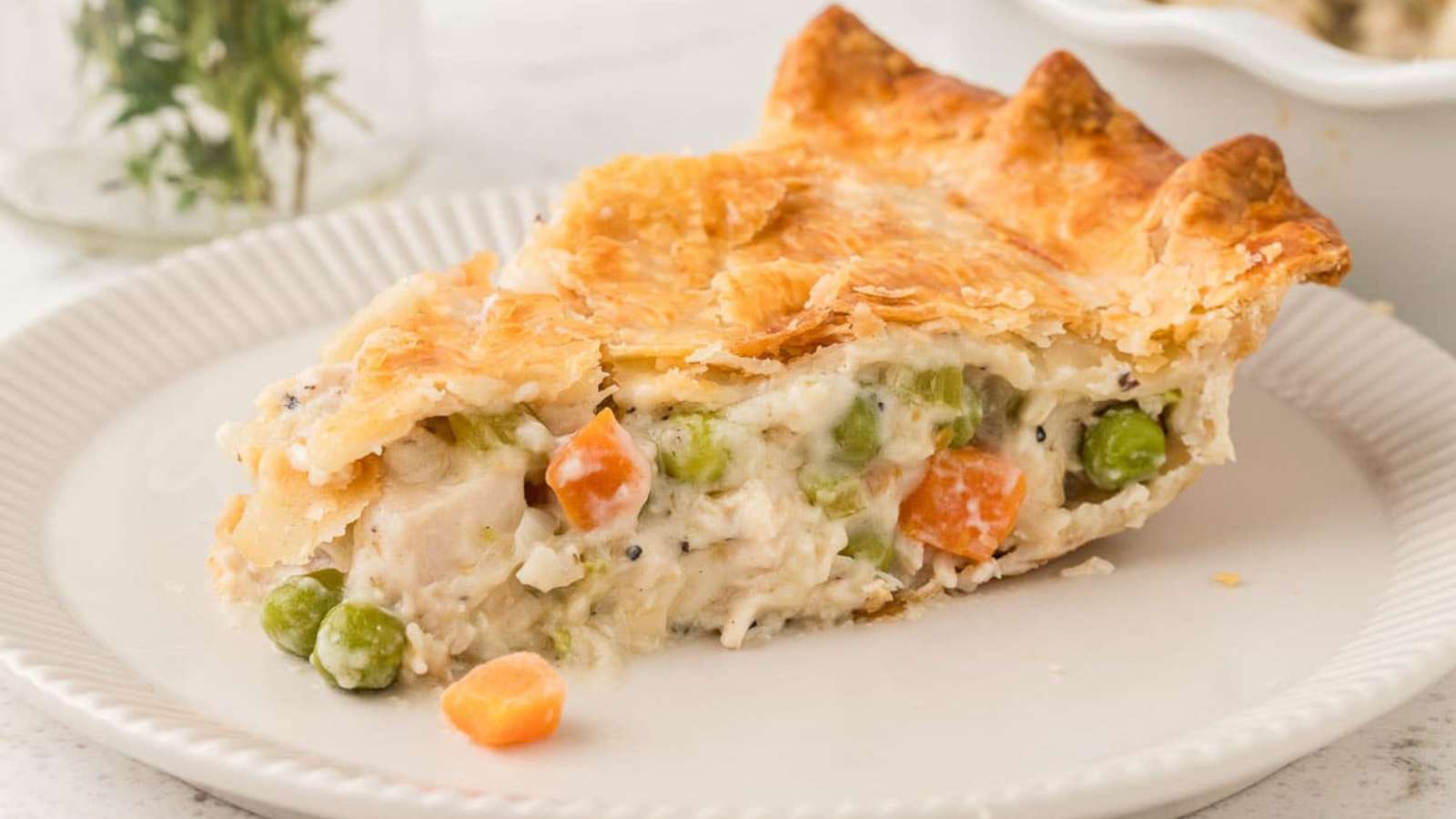 A slice of chicken pot pie on a white plate.