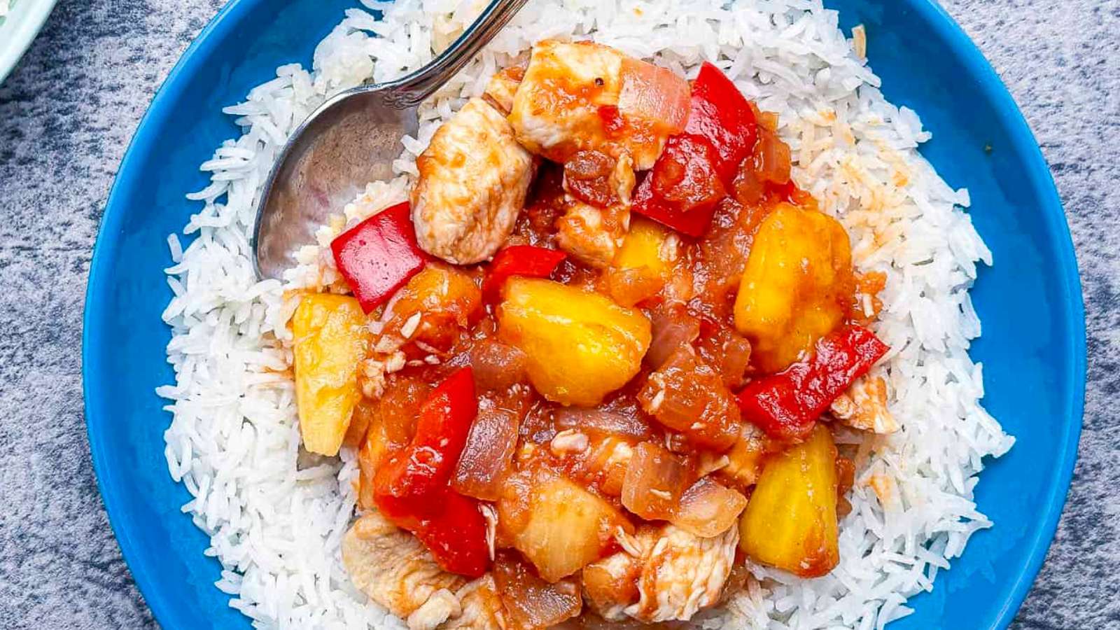 A bowl of rice with pineapple, chicken and salsa.