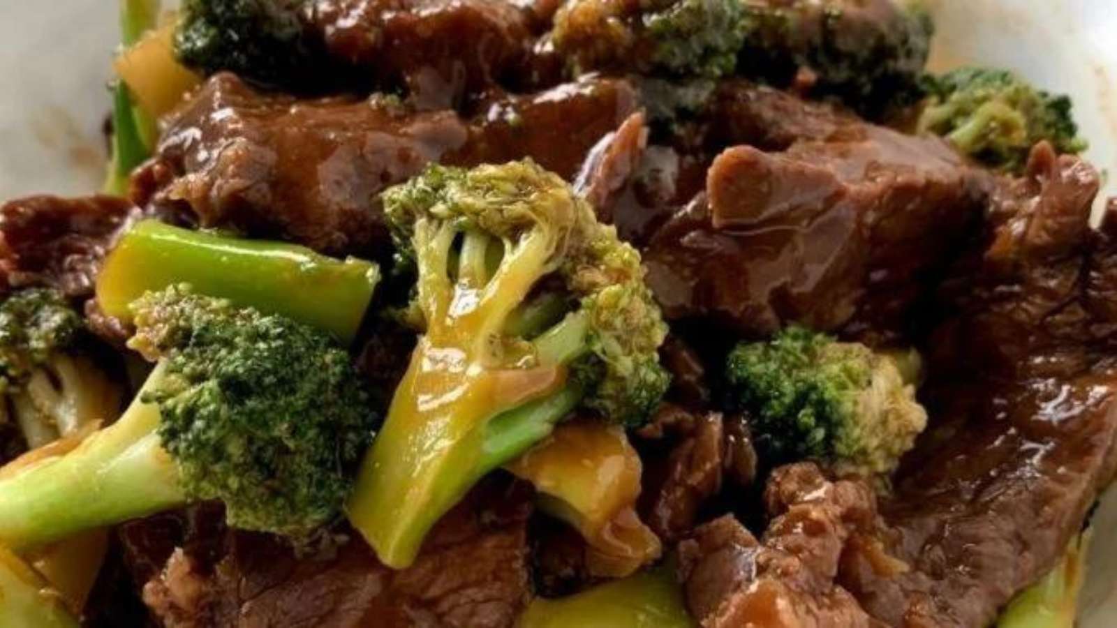 A plate of beef and broccoli in a white bowl.
