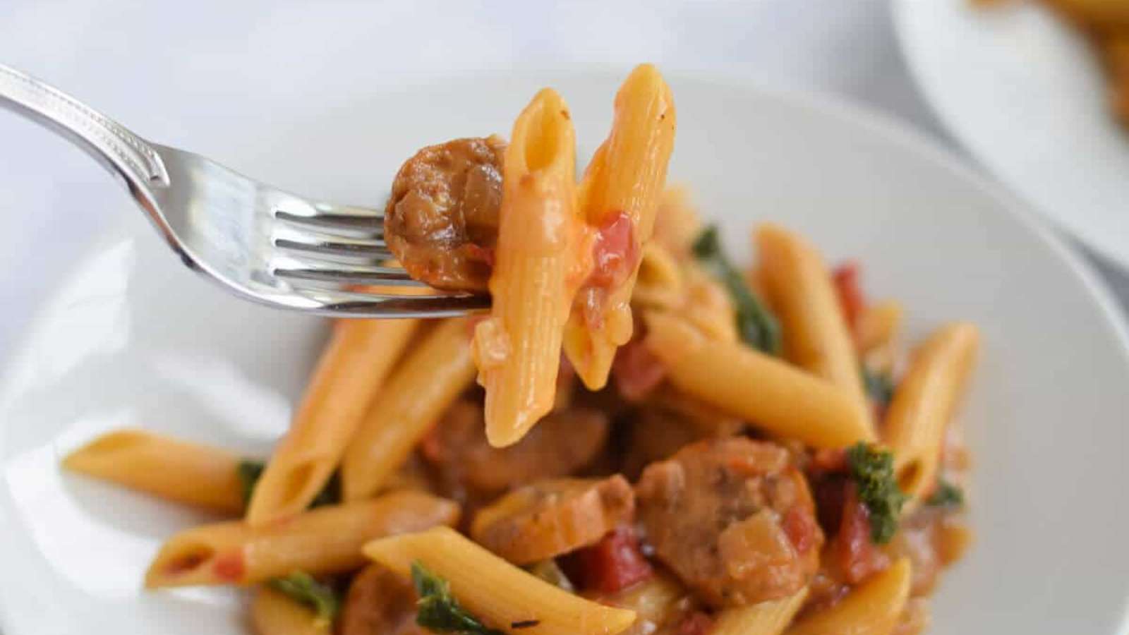 A fork holding pasta with meat and vegetables.