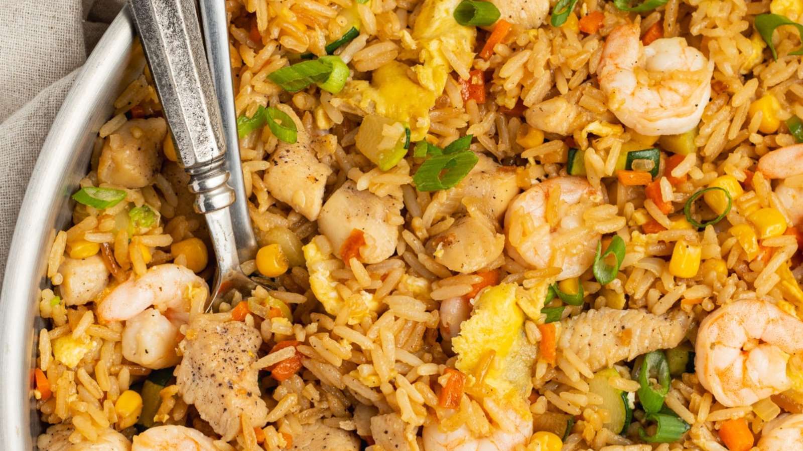 Fried rice with chicken, shrimp and vegetables in a pan.