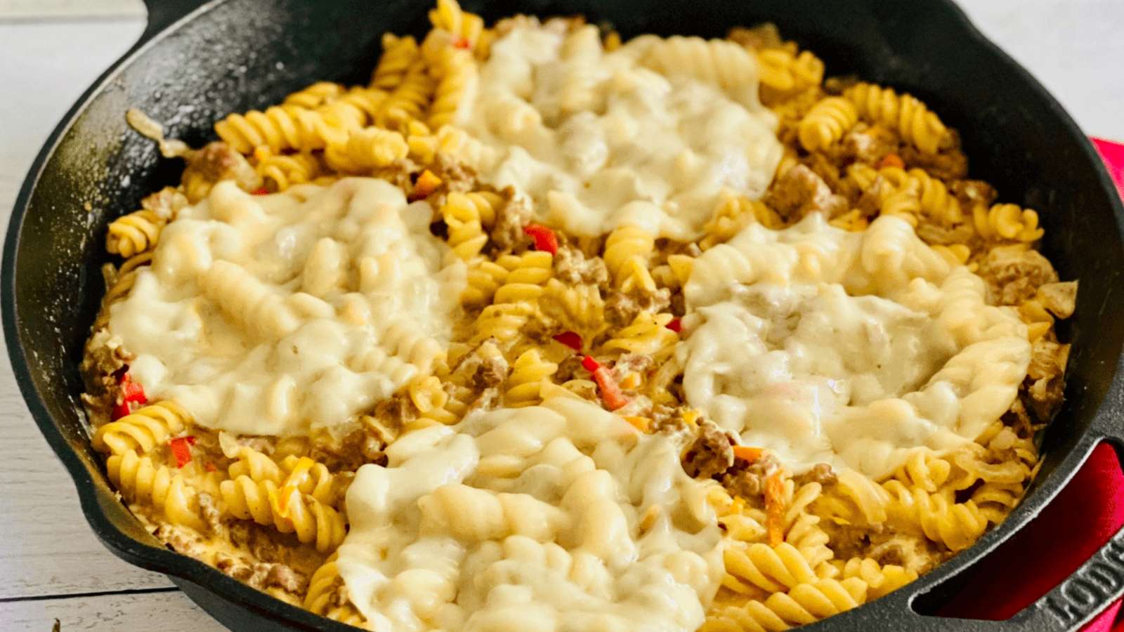 A skillet filled with pasta and cheese.