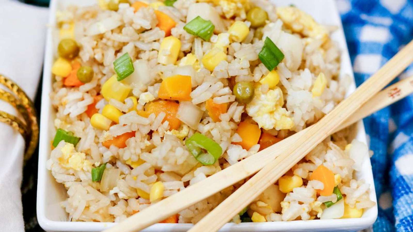Fried rice in a white bowl with chopsticks.